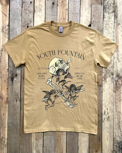 Beige t-shirt with screen printed bones and cherubs design on a wooden background