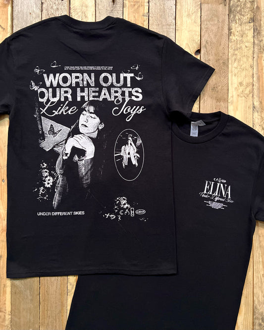 Black t-shirt with large screen printed design on the back and small print on the front on a wooden surface