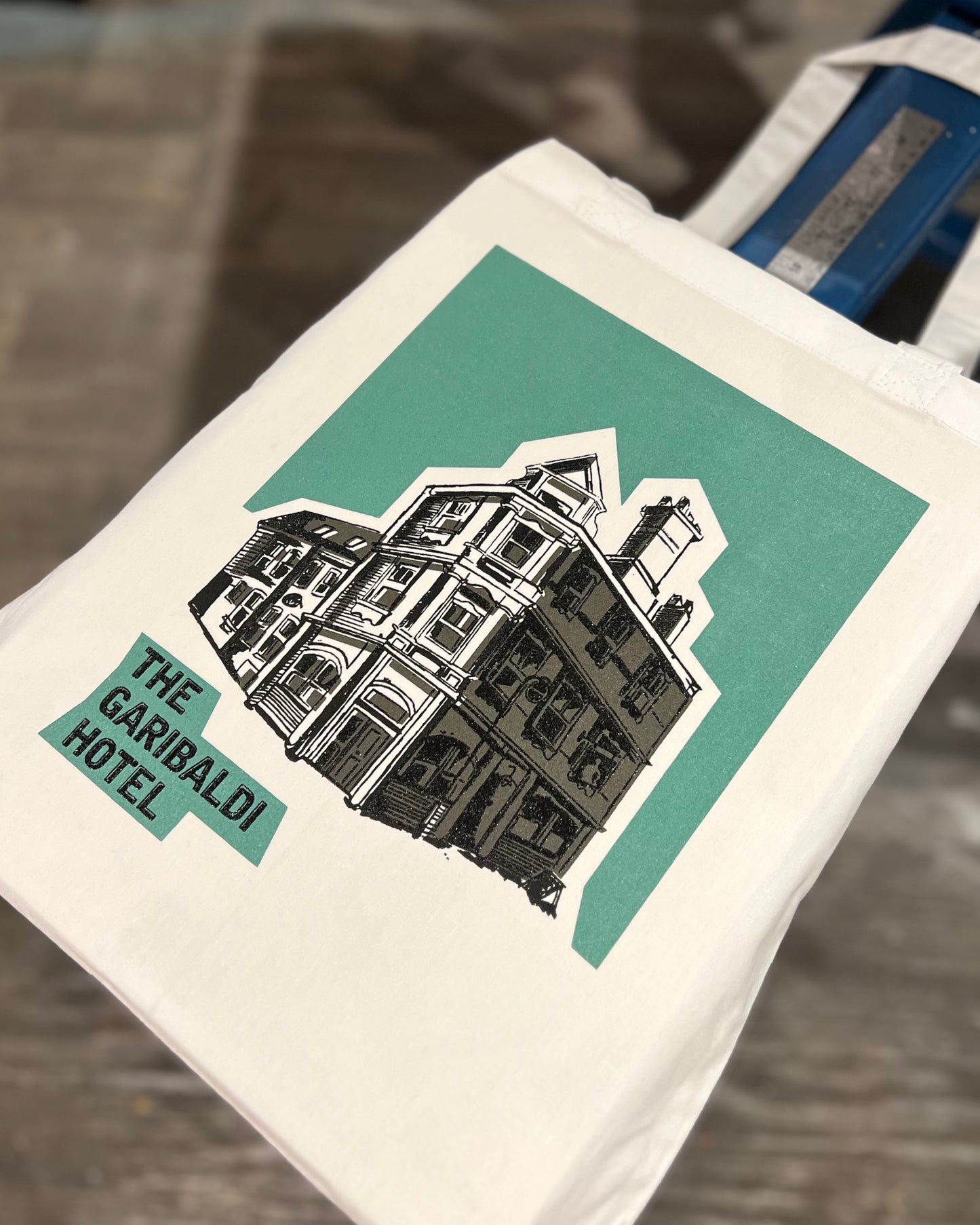 White tote bag with 'The Garibaldi Hotel' graphic design on a screen printing carousel
